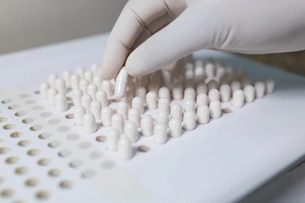 making white capsules. compounding pharmacy. compounding green medication.