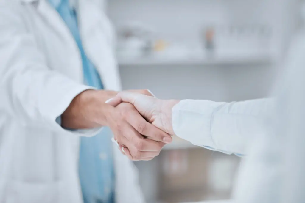pharmacist shaking hands with patient image